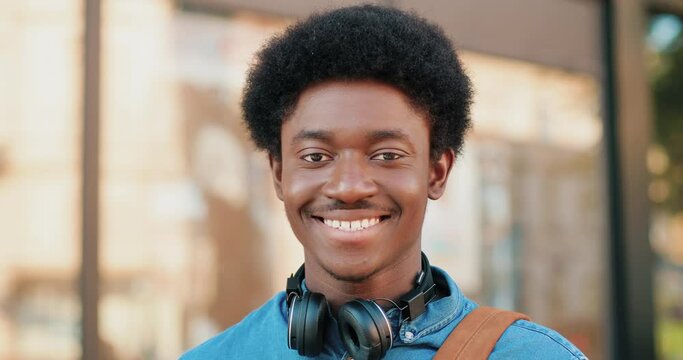 Happy multiracial man. Portrait of the handsome young man showing charming smile and healthy teeth after great walking at the street. People emotions concept