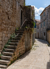 The sun just above the sea horizon creating a sunrise / sunset with a panorama of the mountains and rocky beaches