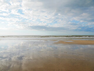 Panoramic view to ocean during low tide of ocean, clouds reflection, Dieppe, France