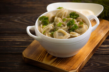 dumplings, dill, sauce on a wooden background