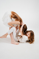 Naklejka na ściany i meble two cheerful girls with long hair in white clothes play, have fun. 