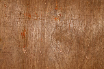 Brown background. Old plywood texture with scratches and dents.
