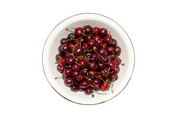 Ripe juicy cherries on a plate top view.A plate with cherries on a white background.