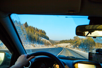 Naklejka premium View from of car interior from side of driver to the road and nature landscape through the windshield