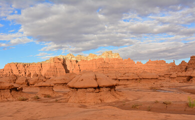 Fototapeta na wymiar Arid wash, colorful peaks, and Bizarre hoodoos at dusk in goblin valley state park, utah 