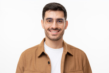 Headshot of handsome young man wearing round glasses, looking straight to the camera with smile,...