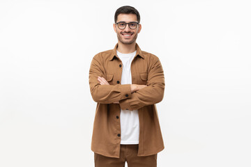 Handsome young man in brown workwear shirt and glasses, feeling confident with arms crossed, standing isolated on gray background