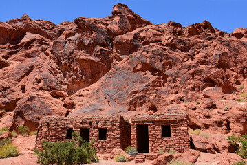    the historic stone cabins built by the civilian conservation corps, set against a backdrop of eroded red sandstone cliffs in valley of fire state park near overton, nevada   