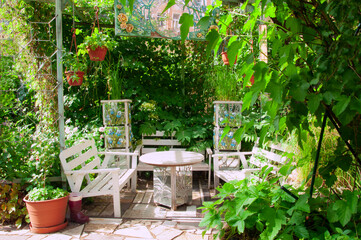Beautiful gazebo in the garden with climbing ornamental plants and on a bright sunny day