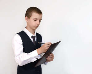 Teenager in school uniform writes on a bright background
