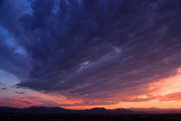 colorful purple-hued sunset over the front range of the colorado rocky mountains, as seen from...