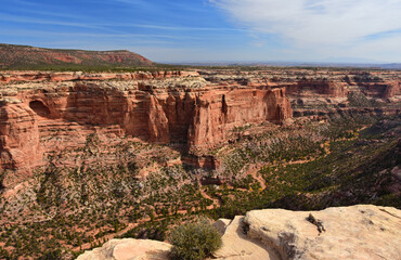 panoramic view  of  eroded red rock cliffs and steep valley from the scenic rim rock drive in colorado national monument,  near fruita, colorado        