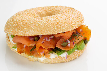 healthy smoked salmon bagel sandwich with cream cheese and avocado isolated on white background.