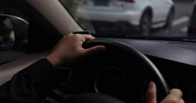 Driving car on city road, hands holding the steering wheel. 