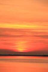 Obraz na płótnie Canvas 市街地から昇る太陽と真っ赤な朝焼け