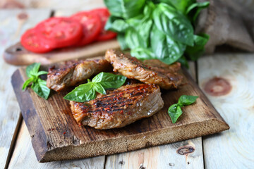 Grilled juicy steak on a wooden board. Steak house serving.