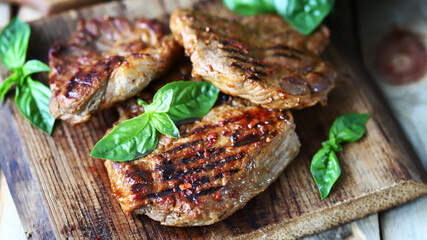 Grilled juicy steak on a wooden board. Steak house serving.