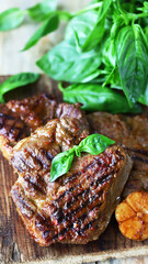 Grilled juicy steak on a wooden board. Steak house serving.