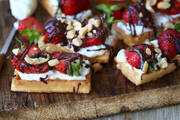 Delicious waffles with strawberries, chocolate and white cheese. Healthy dessert.