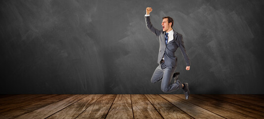 jumping and happy businessman in front of a blackboard