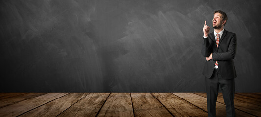 businessman having an idea in front of a blackboard background