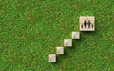 cubes with vaccination and people symbols on grass background