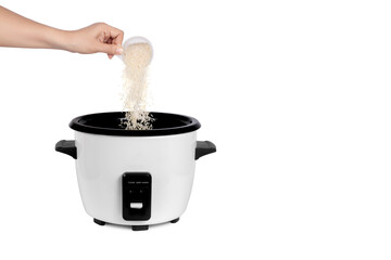 Woman hand pouring rice from measuring cup into Rice cooker isolated on white background 