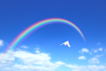 虹に向かって飛ぶ紙飛行機