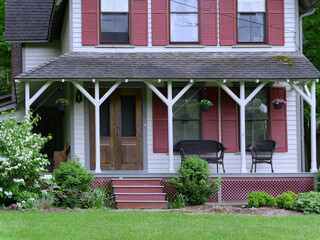 Large old fashioned porch of rural house, with wicker chairs