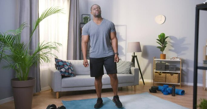 Full length view of the multiracial man preparing to training while having hard workout at home during the self isolation. Sport concept. Stock video