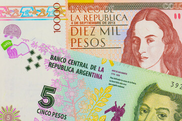 A macro image of a brown ten thousand bank note from Colombia paired up with a colorful five peso note from Argentina.  Shot close up in macro.