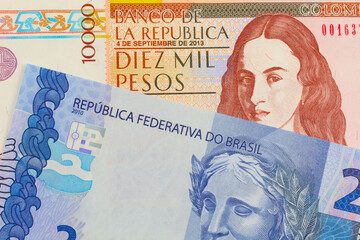 A macro image of a brown ten thousand bank note from Colombia paired up with a blue two real bank note from Brazil.  Shot close up in macro.
