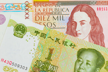 A macro image of a brown ten thousand bank note from Colombia paired up with a green and white one yuan note from China. Shot close up in macro.