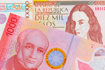 A macro image of a brown ten thousand bank note from Colombia paired up with a colorful red one thousand colones bank note from Costa Rica.  Shot close up in macro.