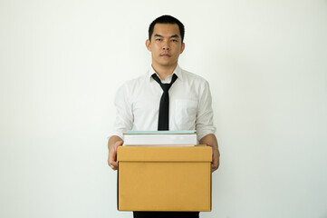 A male office worker is unhappy with being fired from a company packing things into cardboard boxes. The young man was stressed and disappointed by being fired. concept of layoffs and unemployment