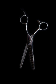 professional barber's hair cutting scissors on black background