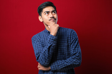 Young handsome man wearing casual shirt thinking worried about a question, concerned and nervous with hand on chin