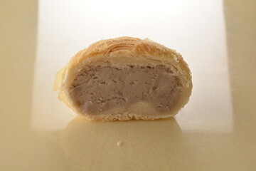 baked round crispy purple yam taro with sweet potato pumpkin sweet paste and egg yolk teochew mooncake on marble table lantern mid autumn festival chinese halal pastry product menu