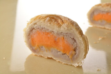 baked round crispy purple yam taro with sweet potato pumpkin sweet paste and egg yolk teochew mooncake on marble table lantern mid autumn festival chinese halal pastry product menu