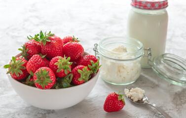 Fresh strawberry in bowl with cottage cheese and milk