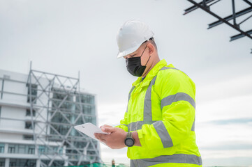Civil engineer inspect construction site structure and plans in tablets. Civil engineer inspects the actual construction site against the plan.  Civil engineer holds a tablet to inspect the building.