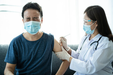 Asian young man very scare a vaccination shot, man having a needle phobia problem.