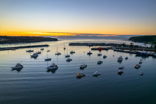Sunrise over the harbour with low cloud bank and boats
