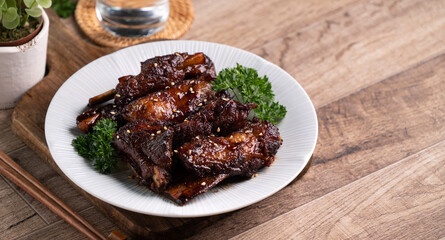 Fototapeta premium Barbecue pork spare ribs in a plate on wooden table background.