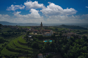 Fototapeta na wymiar Catholic church on a hill surrounded by vineyards. Parish Church of Saints Fermo and Rustico, on a hill in the province of Verona, Colognola Ai Colli, Italy. Italian historic town on a hill.