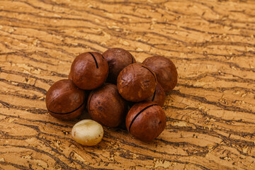 Brown macadamia nut heap over background