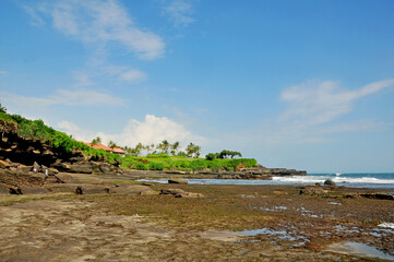 Fototapeta na wymiar Beautiful temple of Tanah Lot at Tabanan regency of Bali Indonesia located with black sand and rock surround it.