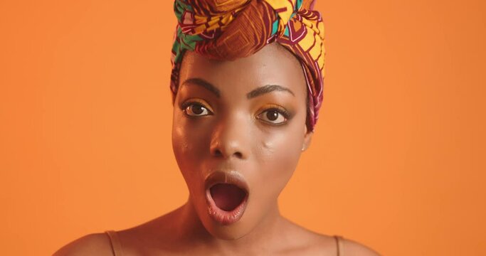 African woman with beautiful makeup shows surprise at the camera. Video where the girl is surprised.