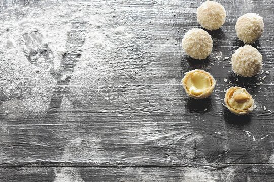Homemade candy white chocolate and coconut on a plate on the table. Candy -truffles snowball/ White coconut balls, raw and healthy sugar free Rafaello candies