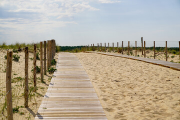wooden path coast access with sand beach waves entrance to ocean atlantic sea
